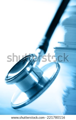 Stethoscope and heap of paper cards in toning