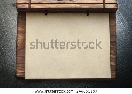 Blank paper notepad with wooden cover on abstract background