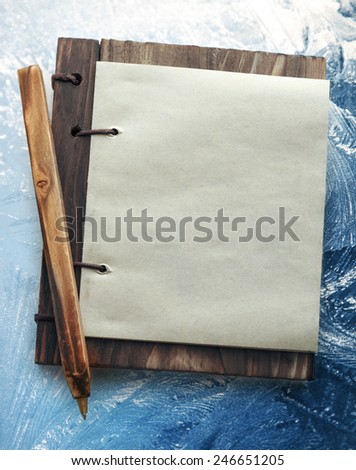 Blank paper notepad with wooden cover on abstract background