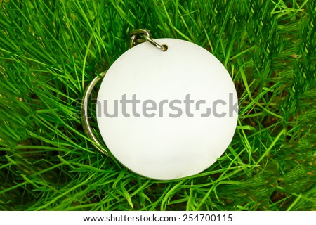 Blank round white badge in green grass