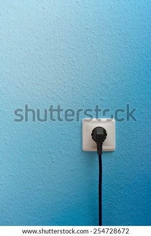 Single electric socket with plug on wall