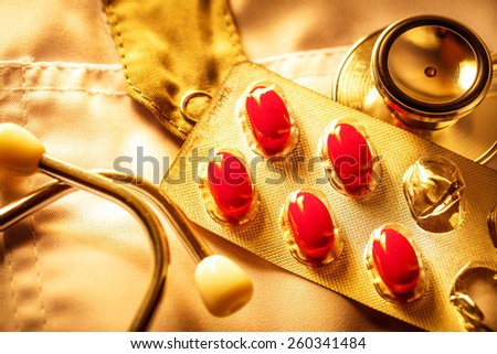Stethoscope and pills on doctor\'s smock in toning