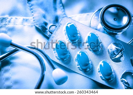 Stethoscope and pills on doctor\'s smock in toning