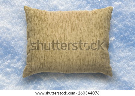 Soft blank beige pillow on snow background