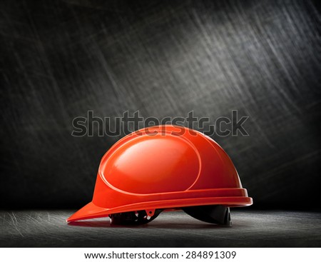 Red safety helmet on steel scratchy background Red safety helmet on steel scratchy background