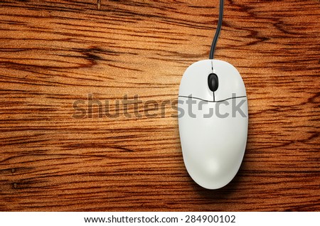 Computer mouse on wooden background  in closeup