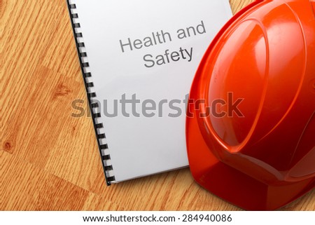 Health and safety register with helmet in closeup