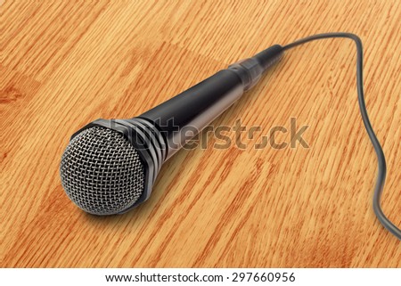 Black microphone on the wooden background closeup
