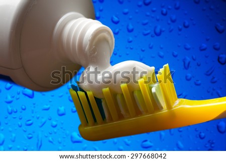Toothbrush and toothpaste on blue water background
