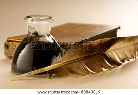 An old book with a feather and the inkpot full of ink