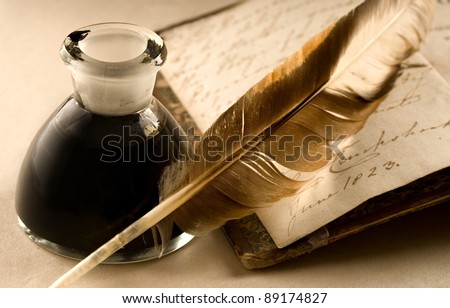 An old book with a feather and the inkpot full of ink