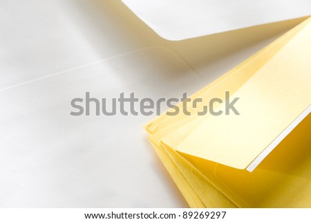 A pile of yellow envelopes over the white one