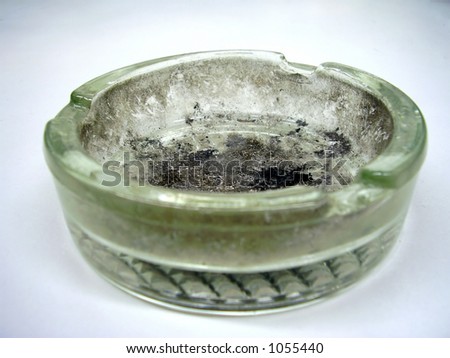 dirty glass ashtray filled with cigarette tar