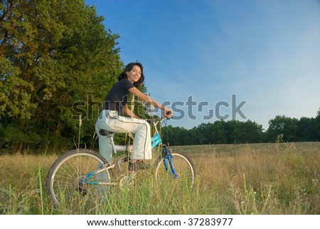 young female riding a bike  in nature
