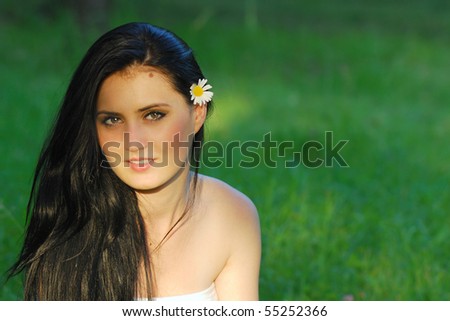 gorgeous young woman sitting in the sun-rays with green background