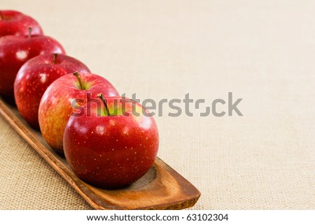 Red crisp apples lined up on an angle on the left with room for text or copy
