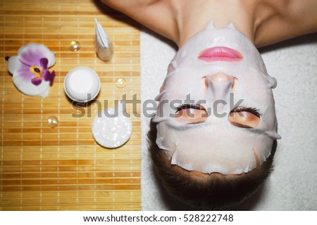 Beautiful natural girl woman in the spa salon, It makes a face mask, facial rejuvenation procedure, spa treatments. Visit a beautician, massage lines. Cosmetology.