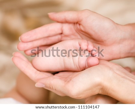 Mother\'s hands  keeping baby\'s foot