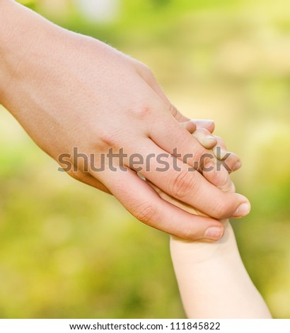 the handle of the child holding fingers of mother
