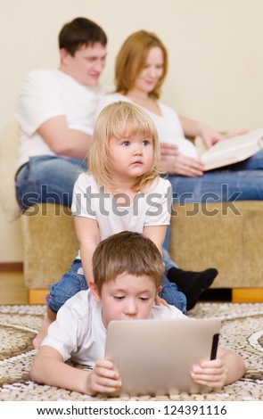 kids using a tablet computer near parents in home