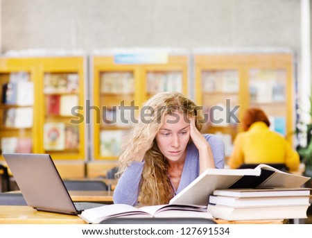 sad student with laptop working in library