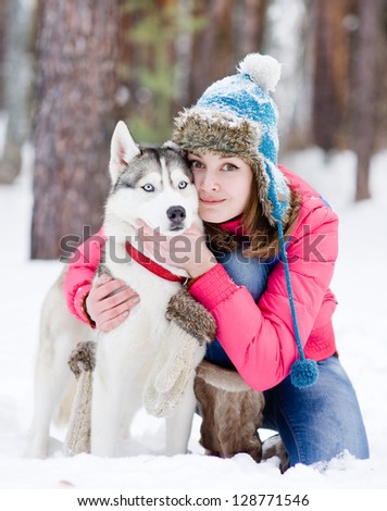 Girl with her cute  dog in the winter forest