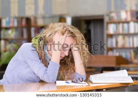 sad student  working in library
