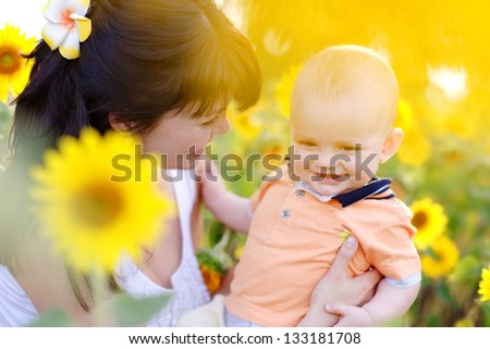 Happy family in spring field of beautiful sunflowers