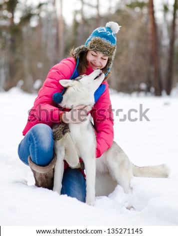 Girl with her cute dog in the winter forest