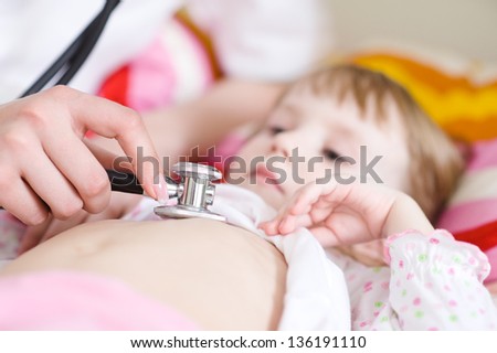 Pediatric doctor exams little girl with stethoscope