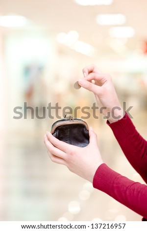 Hands holding  coin and retro styled money pouch in mall