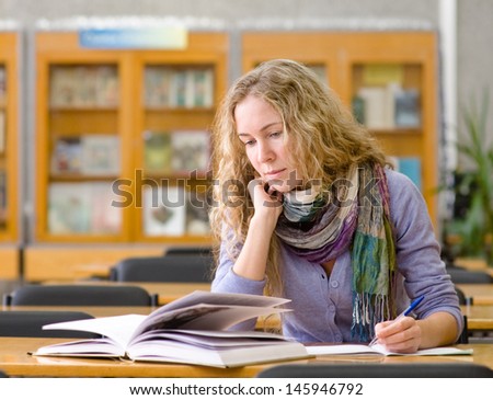 student reads the book in library