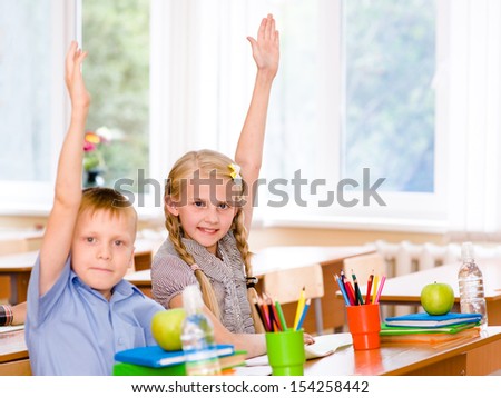 Children raising hands knowing the answer to the question