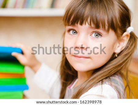 Young schoolgirl takes a book