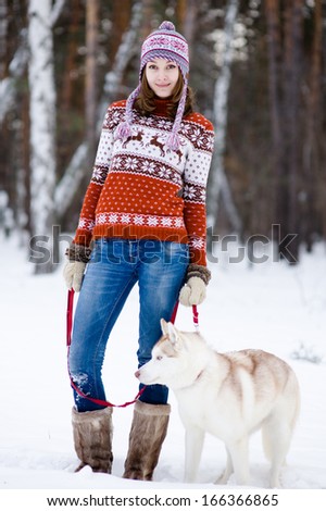 Girl with her cute dog in the winter forest