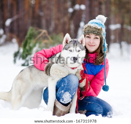 Portrait of a woman with her beautiful dog sitting outdoors
