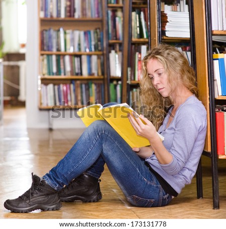the student reads the book on a floor in library
