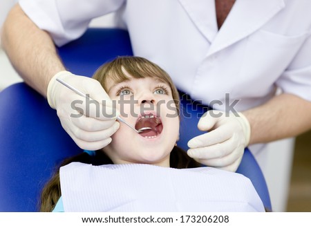 Close-up of little girl opening his mouth wide during inspection of oral cavity