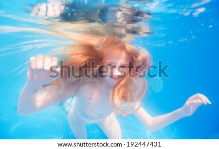 Smiling blonde haired teen girl underwater