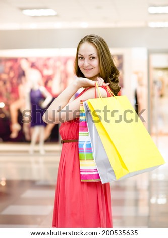 Beautiful young woman with shopping bags in a supermarket