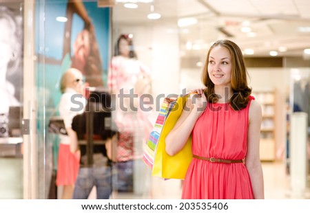 Happy young woman with shopping bags in a supermarket