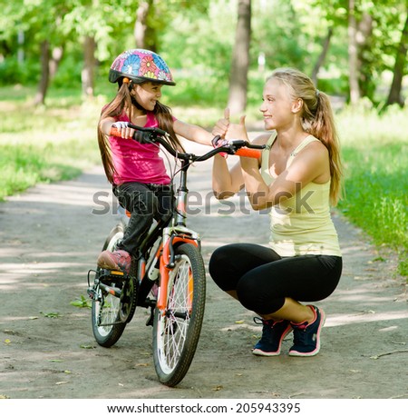 young mother praises her daughter, who learned to ride a bike