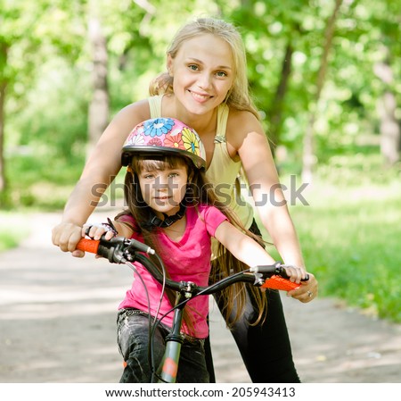 mother and daughter learning to ride a bicycle