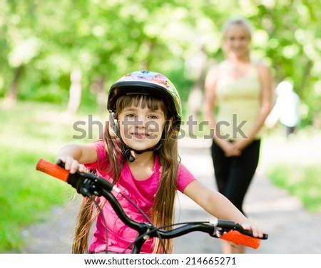 mom and daughter ride bikes in the forest