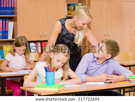 young teacher supervises the students during the exam