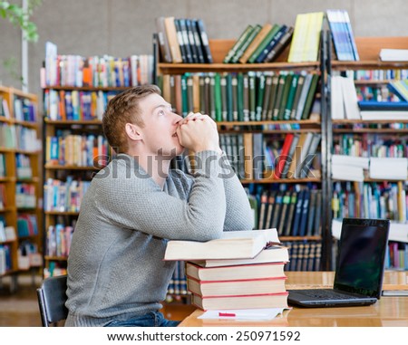 student prays before examination in a library