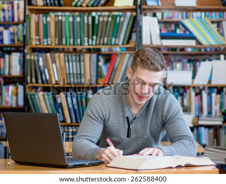 Student with laptop studying in the university library