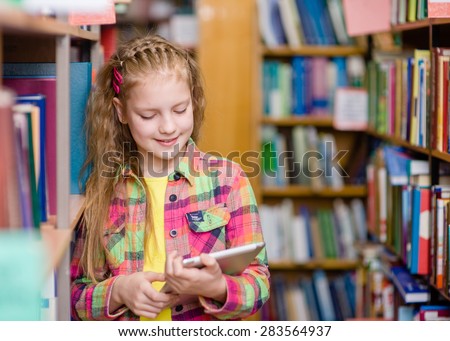 Young girl using a tablet computer in a library