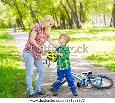 Mom gives his son a bicycle helmet
