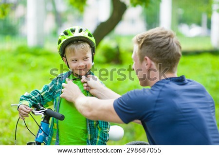 Father wears a protective helmet to his son